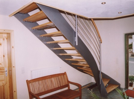 Blechwangentreppe als Metalltreppe gewendelt in Stahl, Geländer in Edelstahl als Reelinggeländer mit Holzhandlauf, Stufen in Holz, Stahltreppe, Metalltreppe