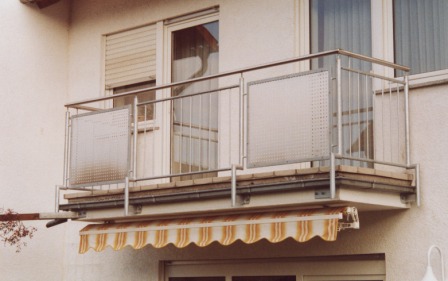 Balkongeländer in Edelstahl mit Lochblech und senkrechten Stäben an einem Beton Balkon als Terrassenüberdachung