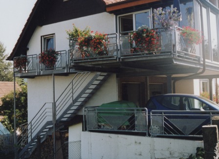 Blechwangentreppe, Metalltreppe, als Außentreppe zum Garten, verzinkt, mit Reelinggeländer zum Außenbalkon, Brüstungsgeländer, Podesttreppe mit Treppengeländer in Stahl