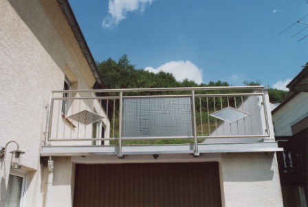 Edelstahlgeländer als Außengeländer über einer Garage, hier ist Lochblech mit senkrechten Stäben kombiniert