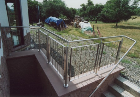 Geländer an Betontreppe als Metallgeländer in Edelstahl und einem Edelstahlhandlauf, ein Treppengeländer ist hier nicht notwendig