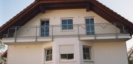 Geländer verzinkt als Balkongeländer an einem Außenbalkon mit senkrechten und schrägen Füllstäben sowie dreieckigen Ornamenten