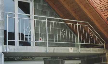 Geländer verzinkt an einem Balkon als Balkongeländer mit senkrechten Füllstäben und Ornamenten in Rautenform