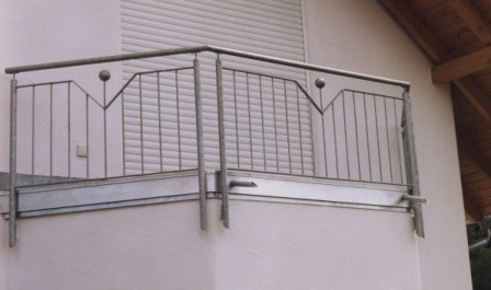 Geländer verzinkt an einem Balkon als Balkongeländer mit senkrechten Stäben sowie zwei Füllstäben mit Verzierung