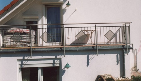 Geländer verzinkt an einem schrägen Balkon als Balkongeländer mit senkrechten Füllstäben und rautenförmigen Ornamenten in Lochblech