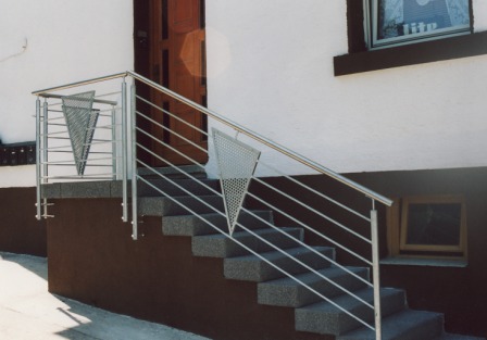 Geländer verzinkt an einer Treppe im Außenbereich, das Treppengeländer besticht durch seine Ornamente in Dreiecksform und die mitlaufenden Füllstäbe