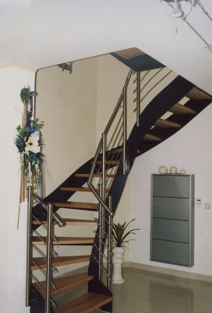 Innengeländer als Metallgeländer an einer Blechwangentreppe, dieses Treppengeländer ist mit mitlaufenden Stäben in Edelstahl an der Metalltreppe ausgeführt, die Stufen sind aus Holz