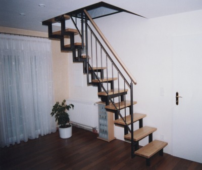 Innengeländer als Metallgeländer mit senkrechten Stäben an einer Zweiholmtreppe, das Treppengeländer ist mit einem Handlauf in Edelstahl, die Zweiholmtreppe ist mit Holzstufen belegt