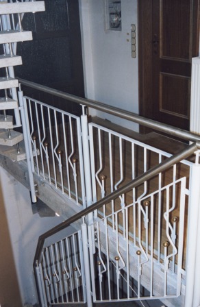 Stahlgeländer als Treppengeländer an einer Steintreppe mit einem Handlauf in Edelstahl und senkrechten Ornamentstäben