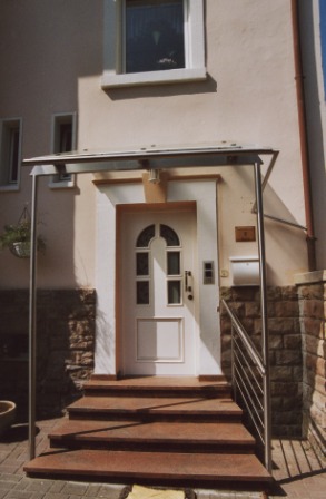 Vordach in Edelstahl an einem Hauseigang mit seitlichem Treppengeländer