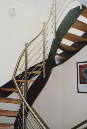  Innengeländer als Metallgeländer an einer gewendelten Metalltreppe, dieses Treppengeländer wurde an einer Blechwangentreppe entsprechend dem Treppenverlauf gebogen, die Holzstufen krönen den Abschluss