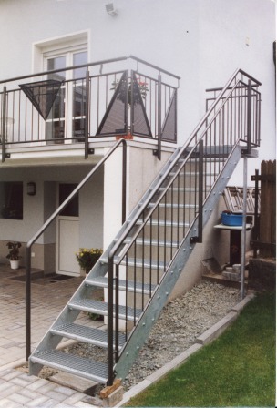 verzinktes Geländer an einem Balkon mit Dreiecken aus Lochblech und einem entsprechenden Treppengeländer