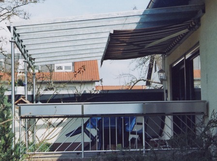 Überdachung mit einem seitlichen Geländer an einer Terrasse mit Sonnenschutz